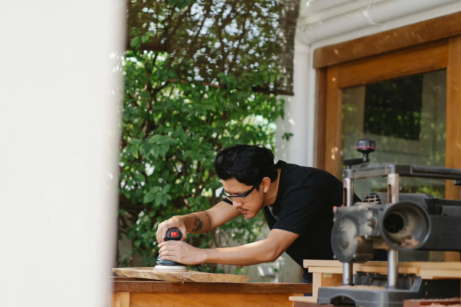 Craftsman sanding wood in furniture workshop